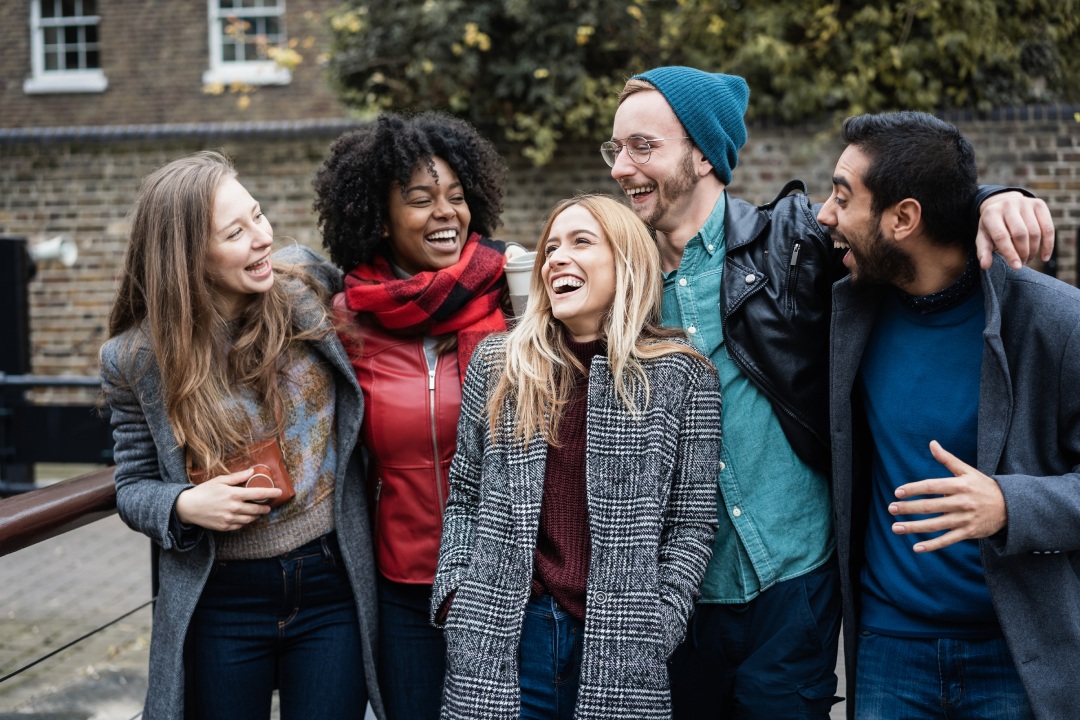 Diverse group of friends laughing together outdoors